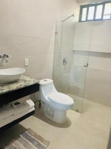 a white bathroom with a toilet and a sink at Comfortable Modern Stays provided by Hidden Gem Vacation Homes in Zapotlanejo