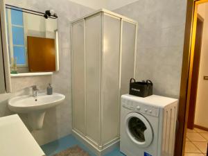 ein Badezimmer mit einer Waschmaschine und einem Waschbecken in der Unterkunft Appartamento a pochi passi dal Duomo in Trient