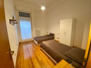 1 Schlafzimmer mit 2 Betten und einem Fenster in der Unterkunft Appartamento a pochi passi dal Duomo in Trient