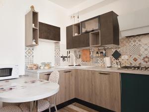 - une cuisine avec des placards en bois et une table blanche dans l'établissement B&B Interno SG, à LʼAquila