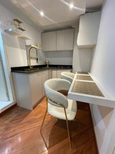 een keuken met witte kasten en een tafel en stoelen bij Lili’s room in Quito