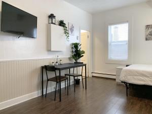 Habitación con mesa, cama y dormitorio. en Cozy Bachelor Condo l Downtown l WiFi & Smart TV, en Moose Jaw