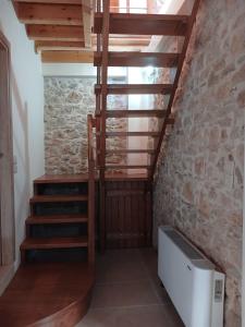a staircase in a room with a stone wall at KALAMOS PLAZA in Kalamos