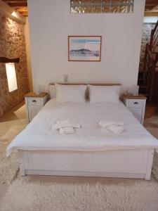 sypialnia z białym łóżkiem i 2 ręcznikami w obiekcie KALAMOS PLAZA w mieście Kalamos