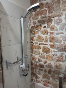 W łazience z kamienną ścianą znajduje się prysznic. w obiekcie KALAMOS PLAZA w mieście Kalamos