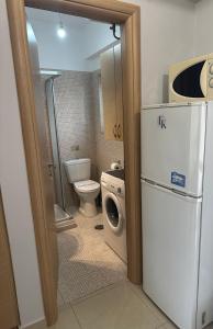 a small bathroom with a refrigerator and a toilet at FK Maison in Agrinio