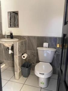 uma casa de banho com um WC branco e um lavatório. em Hotel and Bungalows Palaces em San Patricio - Melaque