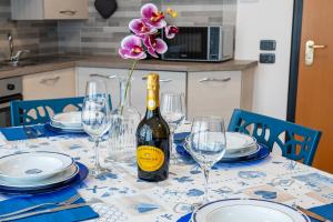 una mesa con una botella de vino y una flor en Casa Cassiopea, en Riva del Garda