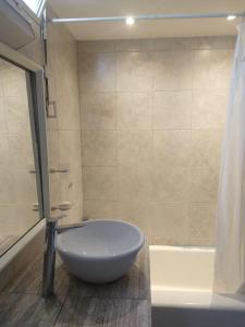 uma casa de banho com uma grande banheira branca e um chuveiro em Habitaciones con baño compartido en Departamento Mid Century Modern em Mendoza