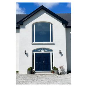 una casa blanca con una puerta negra en Eastbury House P25 C3K8 en Cork