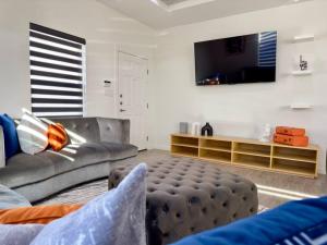 a living room with a couch and a flat screen tv at Brand New Apt! Close to the Mall in McAllen