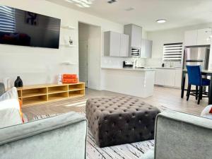 a living room with a couch and a ottoman at Brand New Apt! Close to the Mall in McAllen