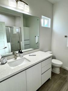 a bathroom with a sink and a toilet and a mirror at Brand New Apt! Close to the Mall in McAllen