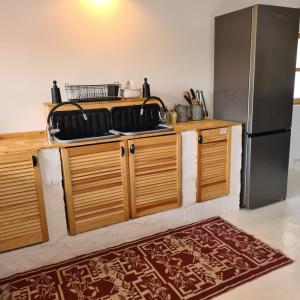 una cucina con armadi in legno e frigorifero di The Origin ● Mountain Guesthouse ● Magura a Măgura