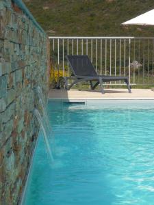 una piscina con un banco junto a una pared en Appartements Candella, en Galeria