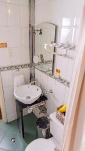 ein Badezimmer mit einem Waschbecken, einem WC und einem Spiegel in der Unterkunft Casa Colonial Quito in Quito