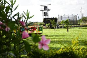 a playground in a park with flowers in the foreground at Koma Gardens and Resort in Nguluni
