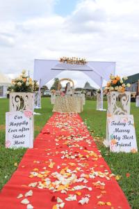 un pasillo rojo y blanco con dosel y flores en Koma Gardens and Resort en Nguluni