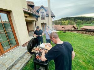 Varvažov的住宿－Chalupa Lodge，一群男人在烧烤架上烹饪食物