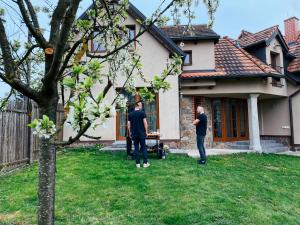 Varvažov的住宿－Chalupa Lodge，两个人站在房子前面的院子中