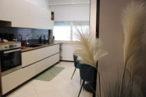 a kitchen with black and white appliances and tall feathers at Cerasè Apartment in center-Sorrento Coast in Vico Equense +23 photos