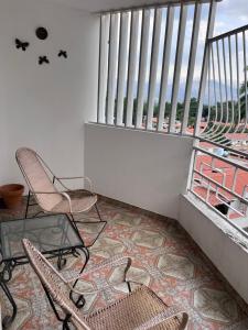 バレンシアにあるTranquilo DEPARTAMENTO SAN DIEGOのバルコニー(椅子2脚、テーブル1台付)、窓2つが備わります。