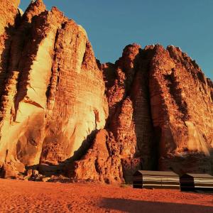 a bench sitting in front of a rock wall at Bedouin bunch camp in Wadi Rum