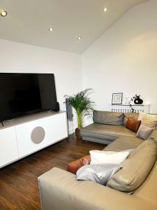 sala de estar con 2 sofás y TV de pantalla plana en The Hideout en Gillingham
