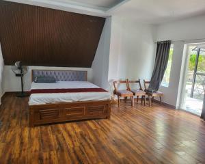 1 dormitorio con 1 cama y 2 sillas en Moon Light Resorts, en Ammāpettai