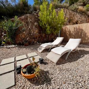 twee stoelen en een potplant op een grinderf bij Casa del Sol in Altea