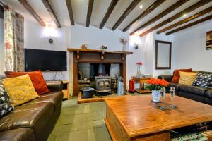 Renovated 5 Bedroom Farmhouse in Picturesque Eskdale, Lake District في إسكاديل: غرفة معيشة مع أريكة وطاولة