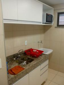 a kitchen counter with a sink and a microwave at Beverly Hills in Aquiraz
