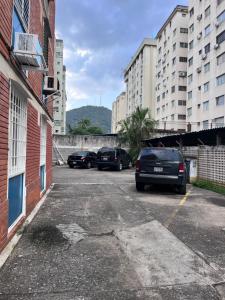 a parking lot with parked cars in a city at TRANQUILO Y ESPACIOSO DEPARTAMENTO AMBASSADOR in Campo de Carabobo