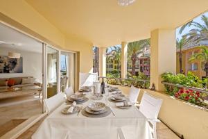 a dining room with a white table and chairs at Vista Marina - Puerto Sotogrande in Sotogrande