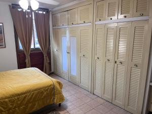 a bedroom with white closets and a bed in it at TRANQUILO Y ESPACIOSO DEPARTAMENTO AMBASSADOR in Campo de Carabobo