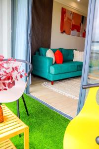 a living room with a green couch and a table at Indesign makumbi park Elegant 2 bedrooms in Nairobi