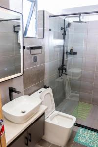 a bathroom with a sink and a toilet and a shower at Indesign makumbi park Elegant 2 bedrooms in Nairobi