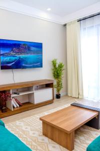 a living room with a flat screen tv on a wall at Indesign makumbi park Elegant 2 bedrooms in Nairobi