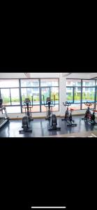 a gym with three exercise bikes in a room with windows at Indesign makumbi park Elegant 2 bedrooms in Nairobi