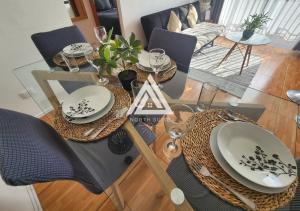 a dining room table with chairs and plates on it at Cómodo Departamento 3 Habitaciones - 1E - Sector Sur in Antofagasta