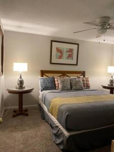 een slaapkamer met een bed en 2 tafels met lampen bij Modern Vast Southern Home with Pool Near Shops in Memphis
