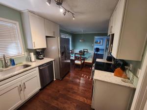 een keuken met een roestvrijstalen koelkast en een eetkamer bij Modern Vast Southern Home with Pool Near Shops in Memphis