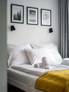 białe łóżko z czterema zdjęciami na ścianie w obiekcie Szczawnica Art w mieście Szczawnica