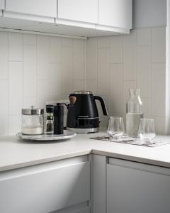 a kitchen with a coffee pot and glasses on a counter at Szczawnica Art in Szczawnica