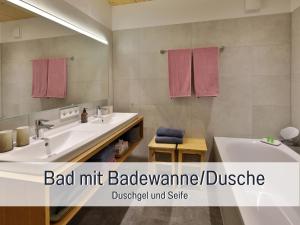 a bathroom with two sinks and a large mirror at Ferienappartment "Beim Schmied" in Chiemseenähe in Traunreut