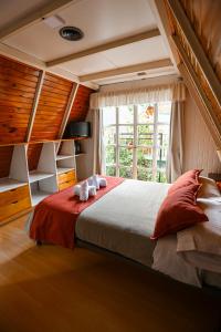 um quarto com uma cama grande e uma janela em Apart Hotel Ensueño em San Martín de los Andes