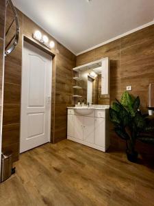 uma casa de banho com uma porta branca, um lavatório e um espelho. em Faluvégi Vendégház Szentgyörgyvár em Szentgyörgyvár