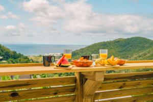 una mesa de madera con fruta y vasos de zumo de naranja en East Lodge appartement, en Sainte-Luce