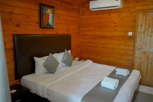 a bedroom with a bed with two towels on it at Seawood beach front resort in Morjim
