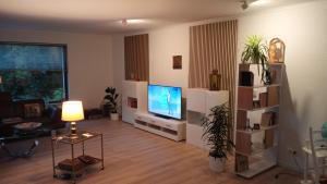 a living room with a flat screen tv and a table at Apartment Messe Hannover in Garbsen